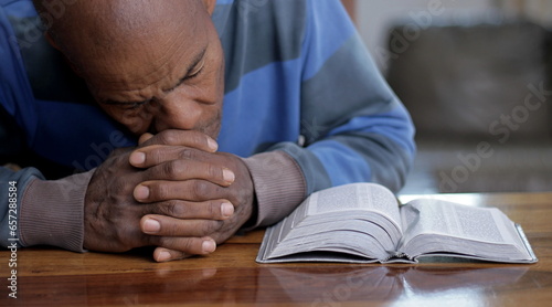 black man praying to god with hands together on grey background with people stock image stock photo