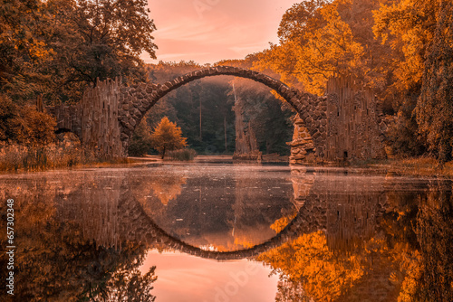 Rakotz Bridge (Rakotzbrucke, Devil's Bridge) in Kromlau, Saxony, Germany. Colorful autumn, reflection of the bridge in the water create a full circle
