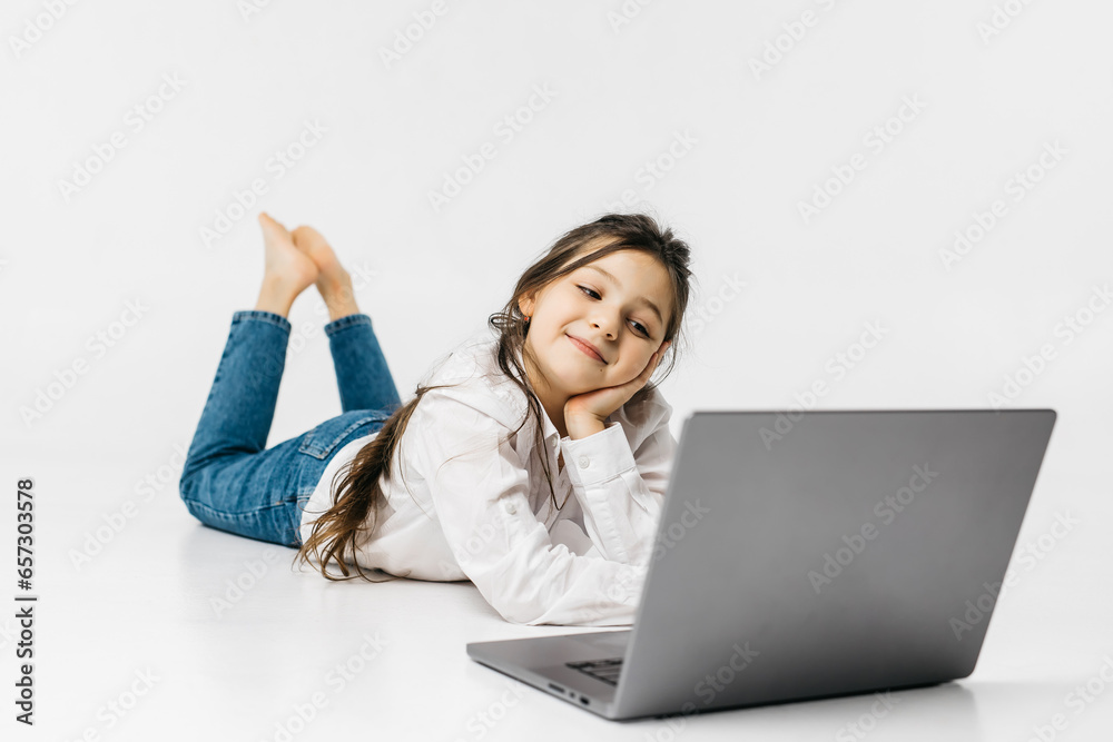 Schoolgirl typing on keyboard using laptop with touch screen, online course of educational lessons at home. Distance learning, distance video conferencing. Schoolgirl studying at school Schoolgirl typing on keyboard using laptop with touch screen, online course of educational lessons at home. Distance learning, distance video conferencing. Schoolgirl studying at school