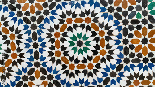Traditional Morocco tiles with Islamic design, handcrafted colorful patterns like geometric shapes and floral motifs. These tiles are used to decorate walls and floors in homes and mosques. photo