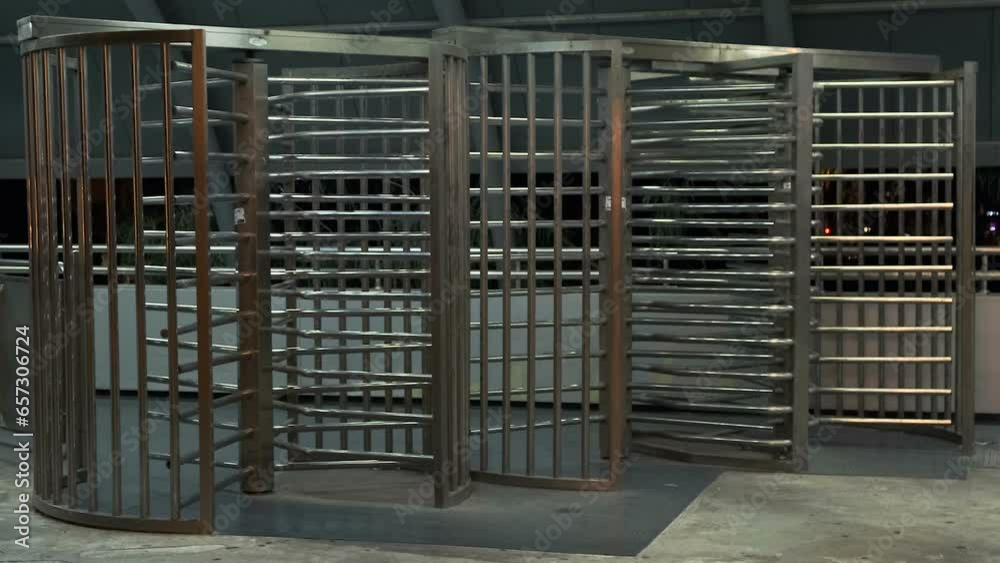 Stainless Steel Rotating Gate in empty entrance security turnstile on the train station in Tel Aviv at night. Turnstile Entry Systems
