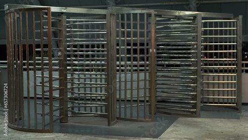 Stainless Steel Rotating Gate in empty entrance security turnstile on the train station in Tel Aviv at night. Turnstile Entry Systems