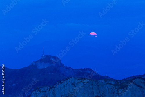 The full red moon rising over the Swiss Alpstein viewed from Schaefler with the summit of Hoherkasten at the background