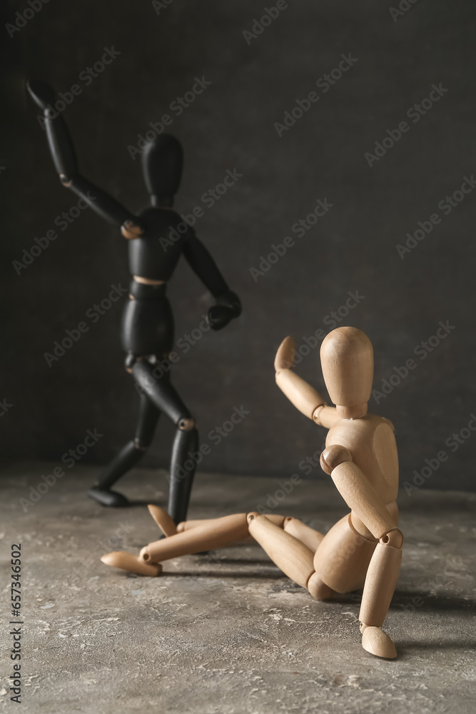 Wooden mannequins on table against dark background. Domestic violence concept - obrazy, fototapety, plakaty 