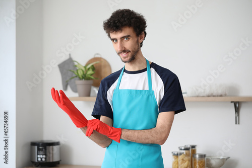 Young man putting rubber gl...