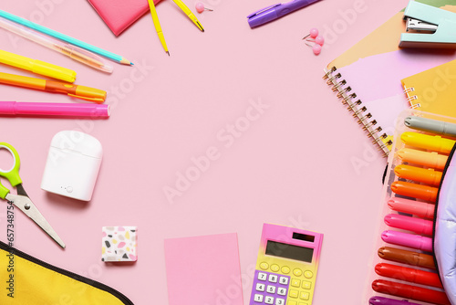 Frame made of calculator and different stationery on pink background