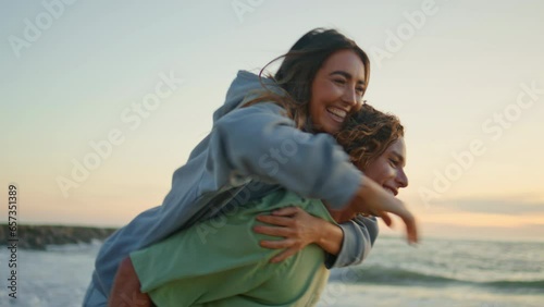 Excited girl jumping boyfriend back sundown closeup. Happy man piggyback woman