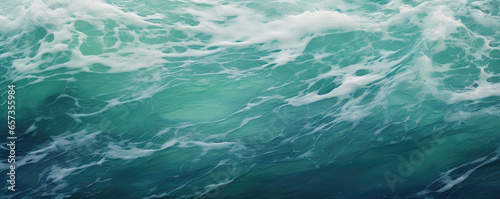 Closeup of turbulent ocean waves, emerald green in color and flecked with bright speckles of sunlight.