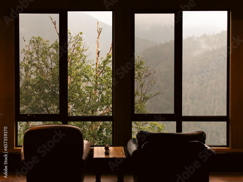 vue de l'intérieur sur une forêt et des montagnes dans le brouillard à travers la fenêtre lors d'une journée d'été photo