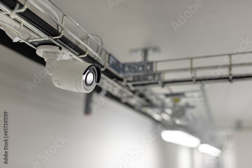 Security camera mounted on a metal structure near the ceiling in the server room. 