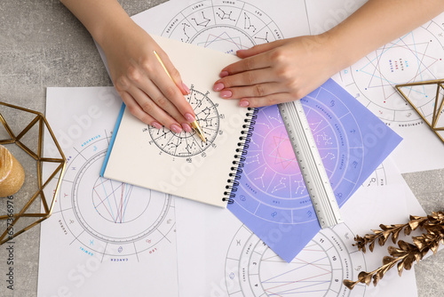 Fotografie Astrologer using zodiac wheel for fate forecast at table, top view