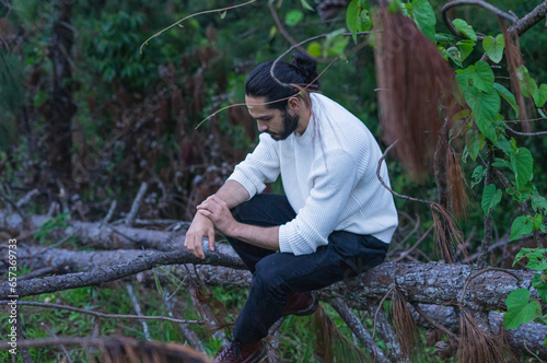 hombre de cabello largo con paisaje montañoso de fonso y sueter blanco photo