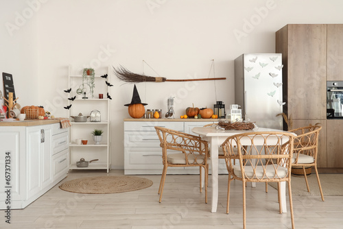 Interior of light kitchen decorated for Halloween with white counters and dining table © Pixel-Shot