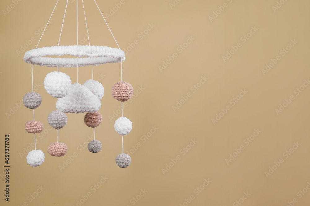 Cute baby crib mobile on beige background. Space for text