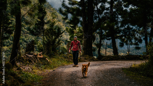 Hombre paseando con su perro en paisaje montañoso photo