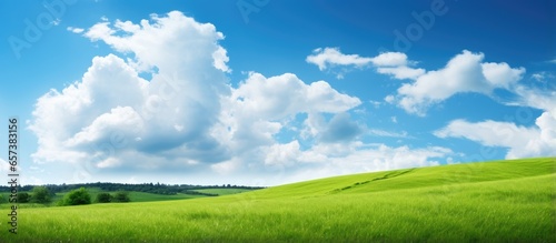 Green grass slope with blue sky and clouds