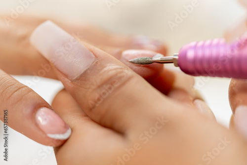 Close-up of a worker polishing the nails of a woman