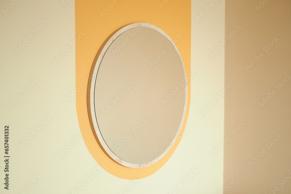 round mirror handing on a wall . round mirror handing on a wall .