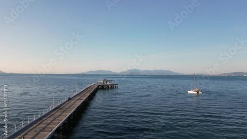 Dock in the blue sea with mountains in the back
