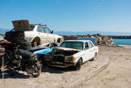 Old and abandoned cars waiting to be collected for the scrapyard in Mathraki island, Greece