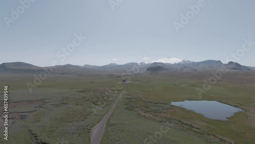 View from above, rural road, glacier and Ingjaldshóll church in distance, Iceland photo