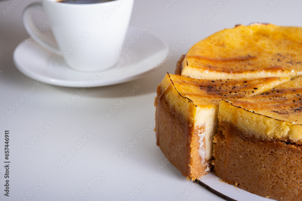 cheese cheesecake with a crust, cut into a piece, on a light dish, background, with a cup of coffee. Preparation of cakes and pastries cheese cheesecake with a crust, cut into a piece, on a light dish, background, with a cup of coffee. Preparation of cakes and pastries