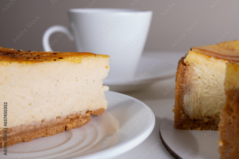 cheese cheesecake with a crust, cut into a piece, on a light dish, background, with a cup of coffee. Preparation of cakes and pastries cheese cheesecake with a crust, cut into a piece, on a light dish, background, with a cup of coffee. Preparation of cakes and pastries