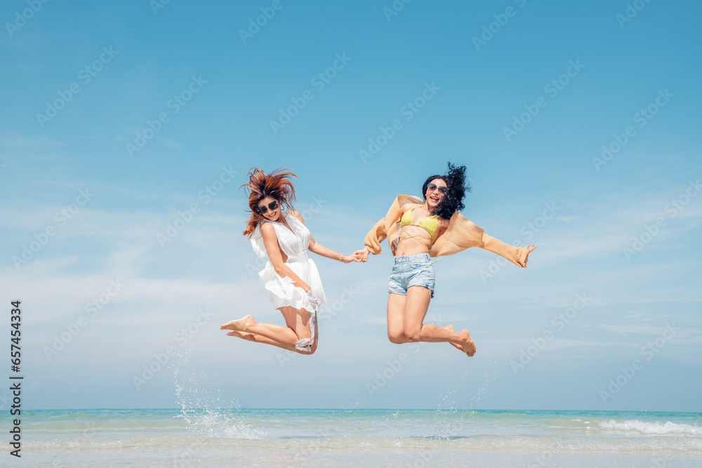 Happy couple woman in bikini walking and playing together on the beach having fun in a sunny day, Beach summer holiday sea people concept.