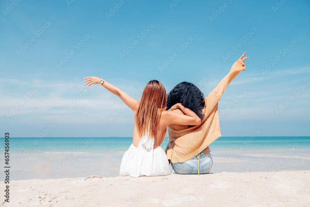 Happy couple woman in bikini sitting and playing together on the beach having fun in a sunny day, Beach summer holiday sea people concept.