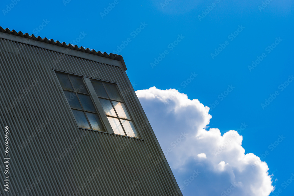 Industrial Building Against Blue Sky with Clouds