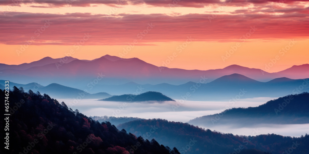 The mountains are shrouded in mist. A twilight shot of autumn mountains under a fading red orange purple sky.