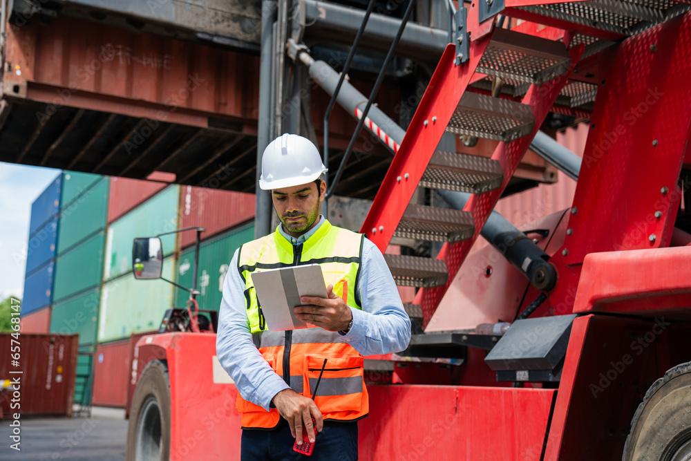 Male Industrial Engineer in White Hard Hat using digital tablet checking container at container yard warehouse. Logistics business. Male Industrial Engineer in White Hard Hat using digital tablet checking container at container yard warehouse. Logistics business.