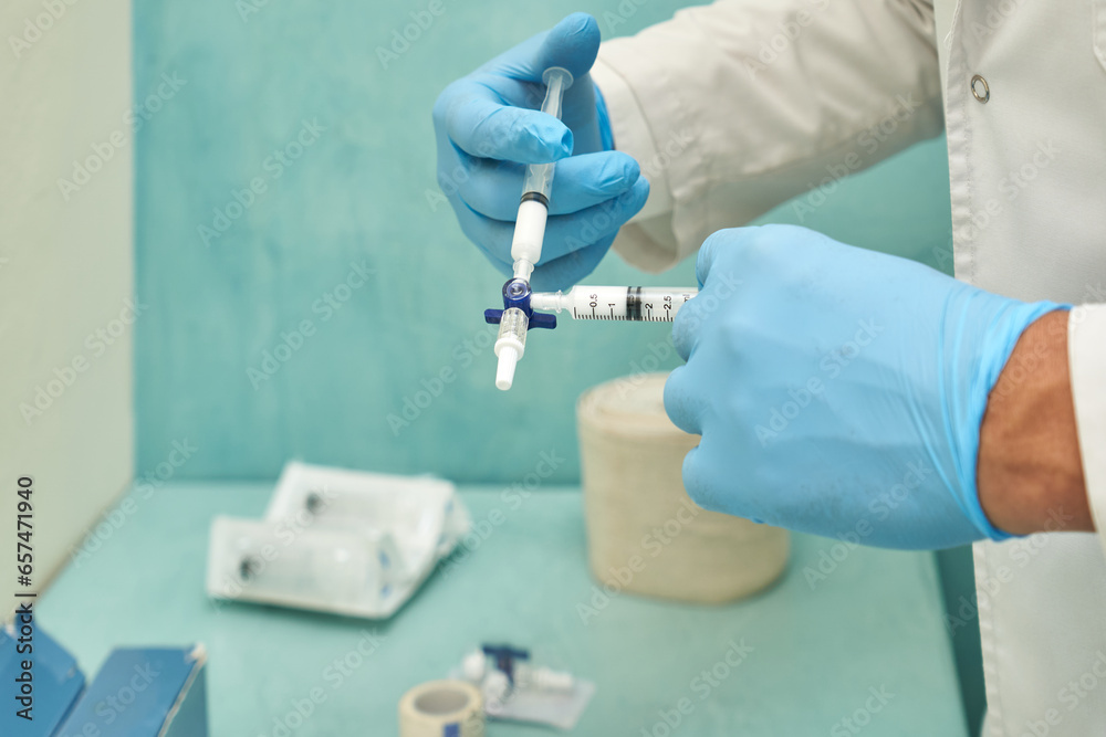 Hand of a doctor with rubber glove filling syringe Hand of a doctor with rubber glove filling syringe