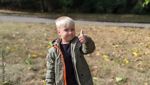 cute funny boy child blond on the street in the park