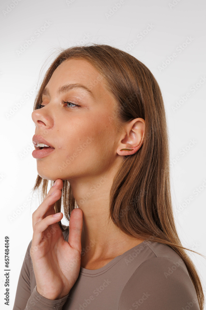 Beautiful young girl with fresh healthy skin. Woman advertise ear-rings. White background. Earrings, ear caffs closeup. Blond european woman with long hair with big lips, pretty smile. Cosmetology Beautiful young girl with fresh healthy skin. Woman advertise ear-rings. White background. Earrings, ear caffs closeup. Blond european woman with long hair with big lips, pretty smile. Cosmetology