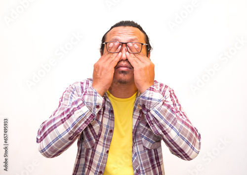 Tired and unhappy man rubbing eyes with fingers putting glasses, covering face with hands feeling sadness, suffering from depression.