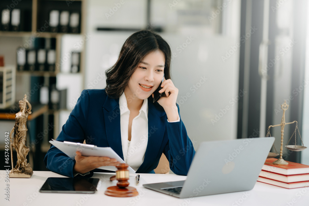 Asian lawyer woman working with a laptop and tablet in a law office. Legal and legal service concept.