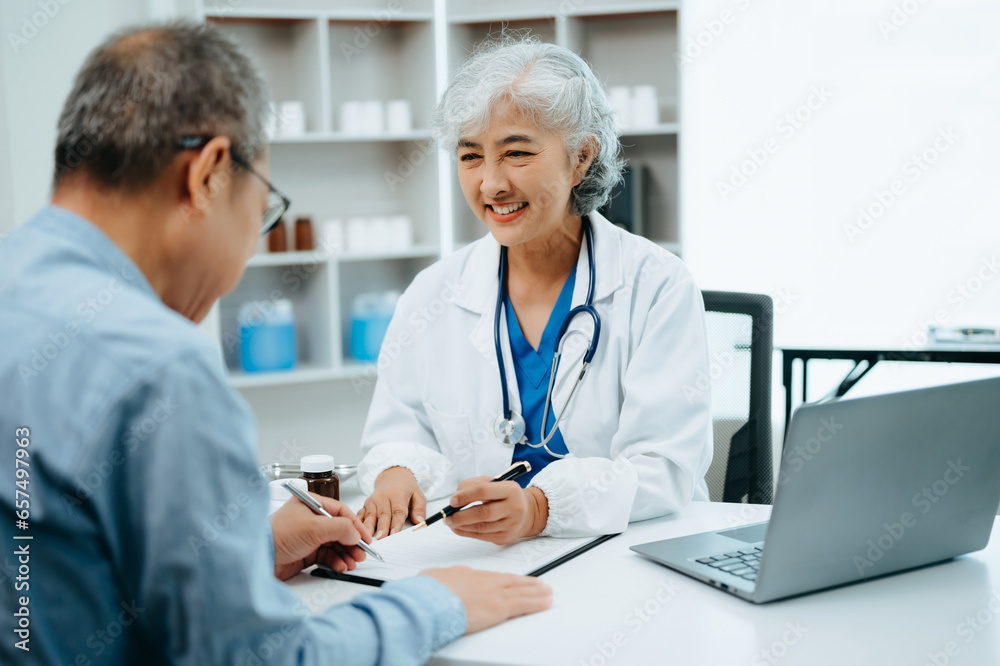 Asian Senior Doctor and patient discussing something while sitting at the table . Medicine and health care concept. Asian Senior Doctor and patient discussing something while sitting at the table . Medicine and health care concept.