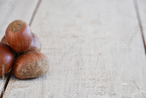 Fresh chestnuts on the white wooden table with copy space. photo