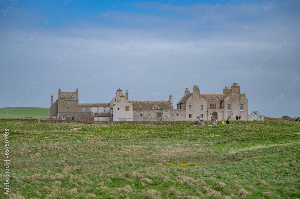 Skaill House at Orkney Island, view from the distance with meadow in front during cloudy day, Kirkwall, Scotland