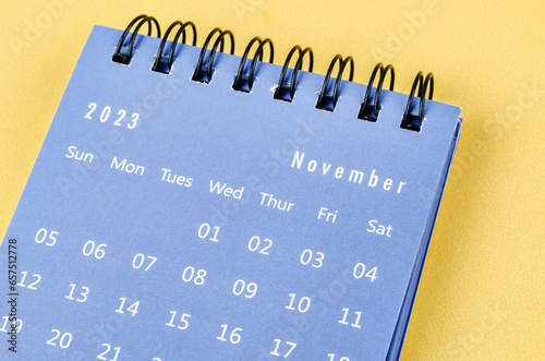 The November 2023 Monthly desk calendar for 2023 year on yellow background. photo