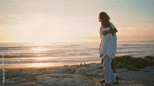 Happy pair playing dog sunset ocean. Loving teenagers embracing at sandy beach