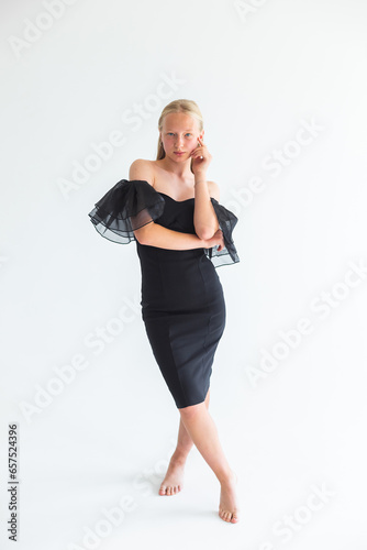 Young pretty blondie woman in black dress on isolated white background. Natural beauty, caucasian girl