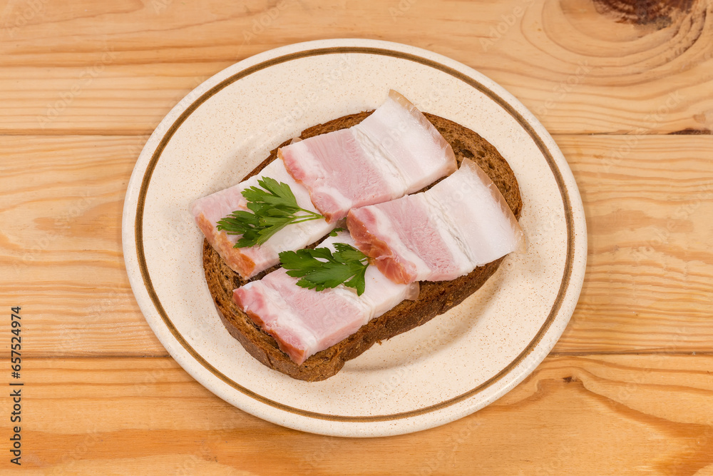 Open sandwich with boiled-smoked pork belly slices on saucer Open sandwich with boiled-smoked pork belly slices on saucer