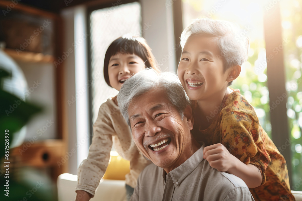 Meeting of grandfather and grandchildren. An elderly Asian man and his grandchildren are happy together. They hug and rejoice at meeting each other. Caring for the elderly. Children visit old people. Meeting of grandfather and grandchildren. An elderly Asian man and his grandchildren are happy together. They hug and rejoice at meeting each other. Caring for the elderly. Children visit old people.