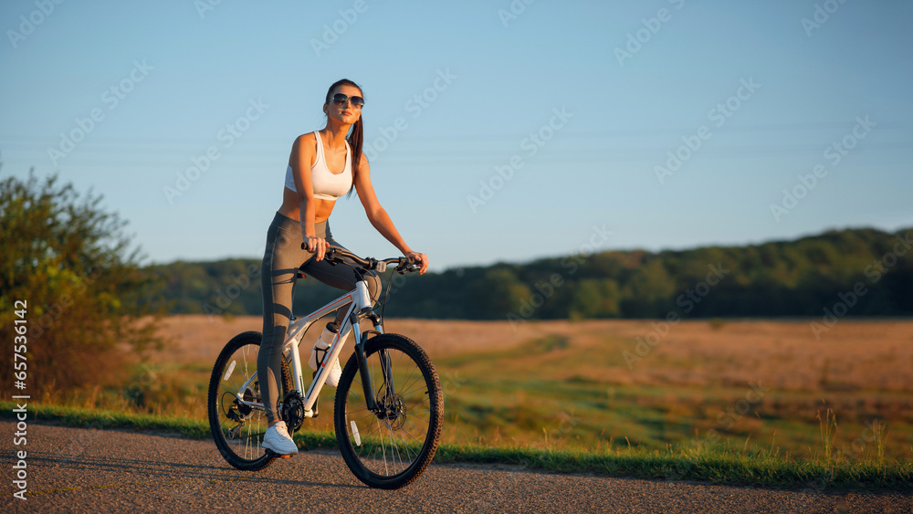 Brunette fit woman in sportswear with bicycle