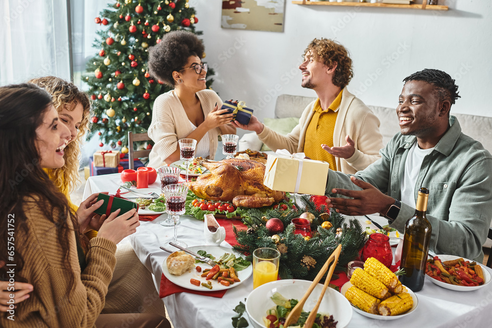 big cheerful and multiracial family having great time celebrating Christmas and exchanging gifts