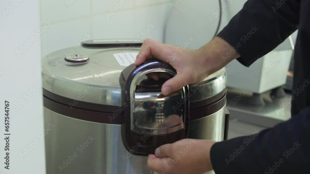 Chef Inserts Pot In Automated Rice Cooker. Kitchen Appliance. Electric