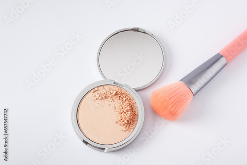 Beautiful eyeshadow palette on white with crushed sample and makeup brush. Makeup product