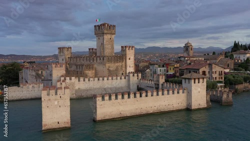 Scaliger Castle of the city of Sirmione 4K video on drone. The historical part of the city of Sirmione on Lake Garda in Italy, shot with Drone. Cumulus clouds at sunrise Sirmione. photo